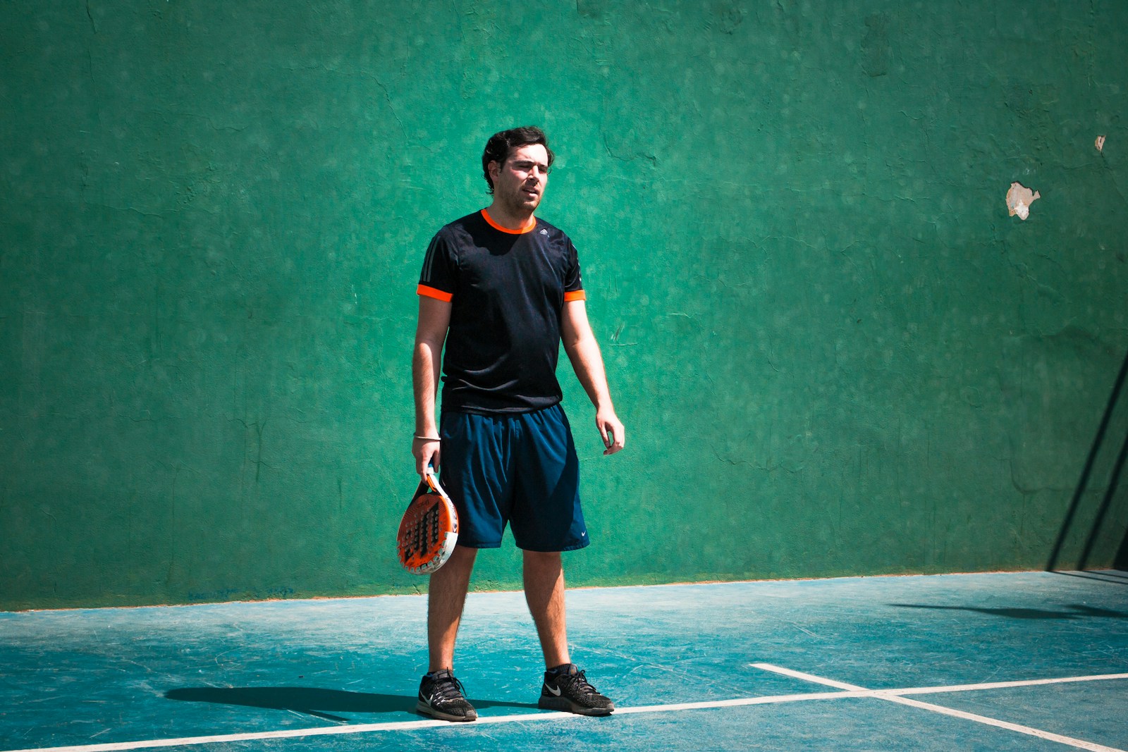 a man standing on a tennis court holding a racquet