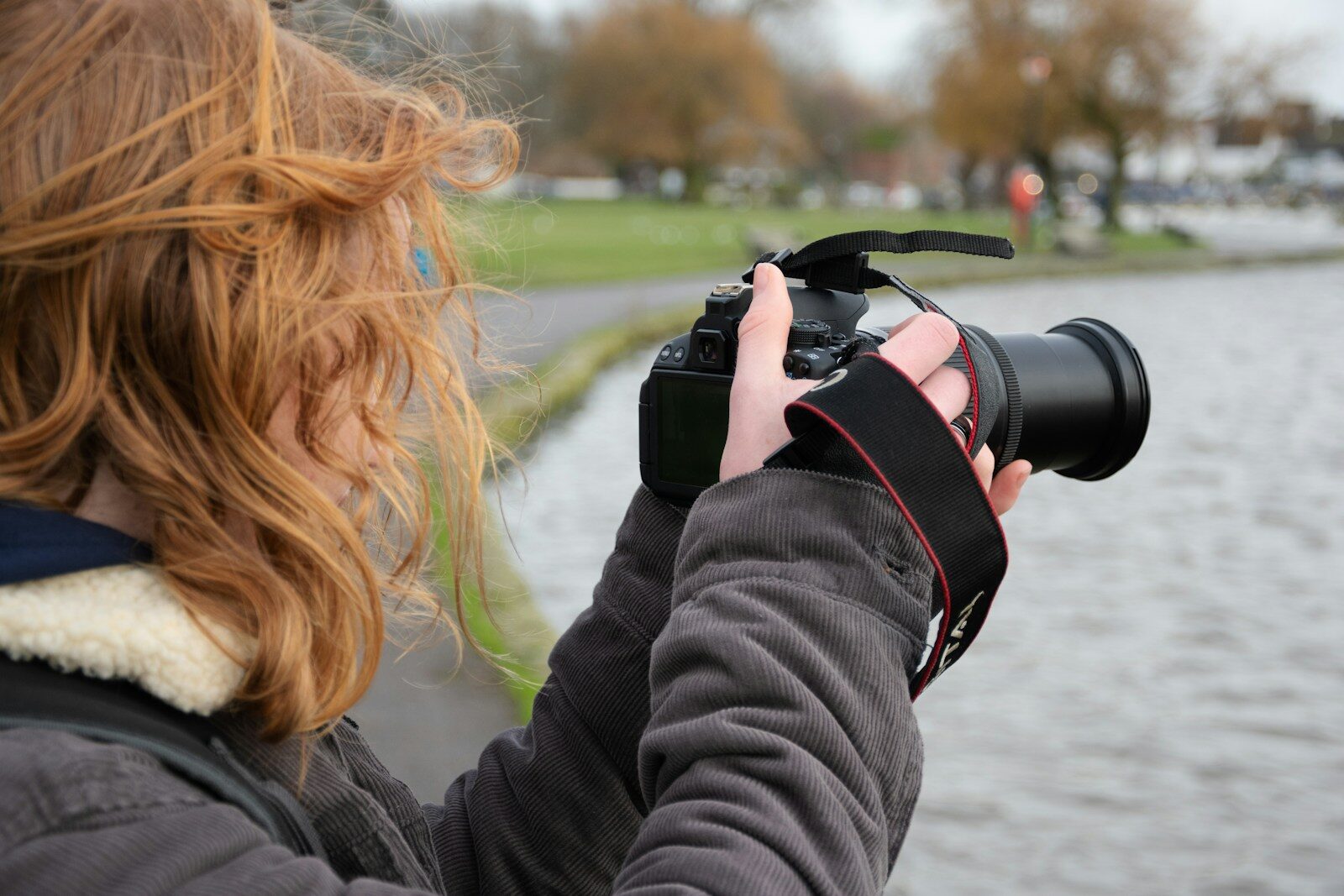 a woman taking a picture of a body of water